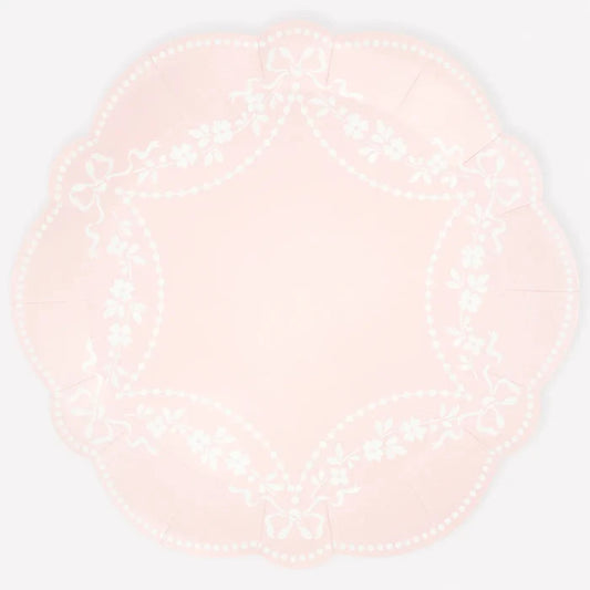 Round pink plate with white pattern on a light white background