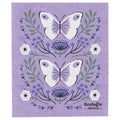 Swedish dishcloth with lavender background featuring two large white butterflies with light purple wing details, surrounded by green leaves, small blue flowers, and a few white blossoms.