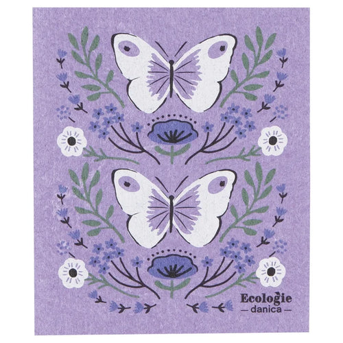 Swedish dishcloth with lavender background featuring two large white butterflies with light purple wing details, surrounded by green leaves, small blue flowers, and a few white blossoms.