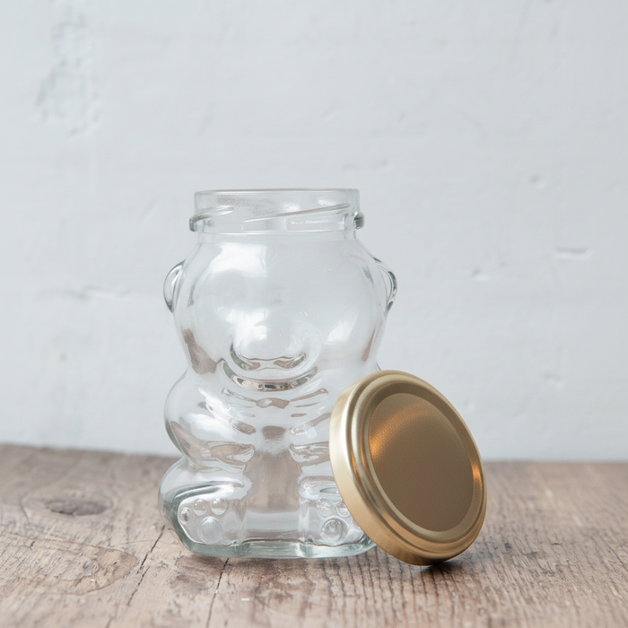maman teddy bear glass jar with gold lid — front view on rustic wood