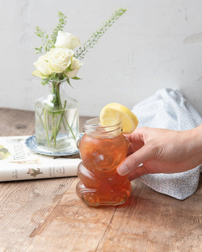maman teddy bear glass jar with gold lid used as drinking glass with juice and lemon