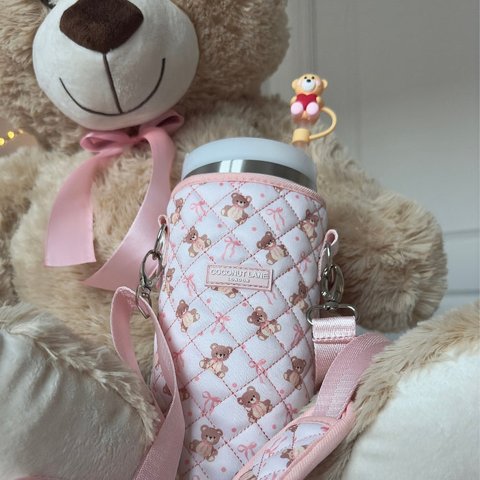 Light brown Coconut Lane Teddy Love straw cover with silicone topper and quilted holder held by a plush teddy bear.