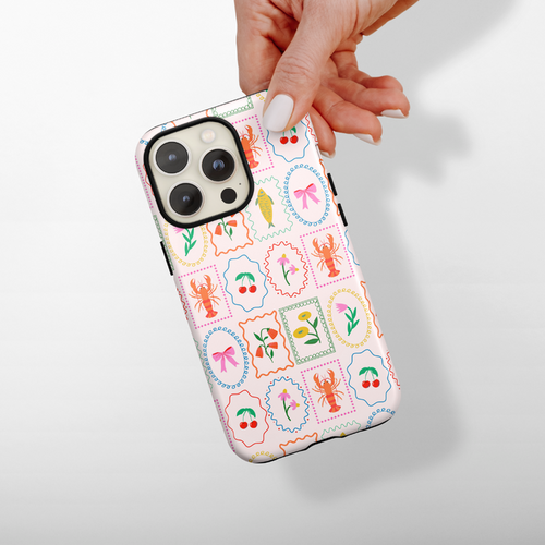 Coconut Lane Tough MagSafe® phone case with playful lobster, flower, bow, and leaf pattern held in hand.