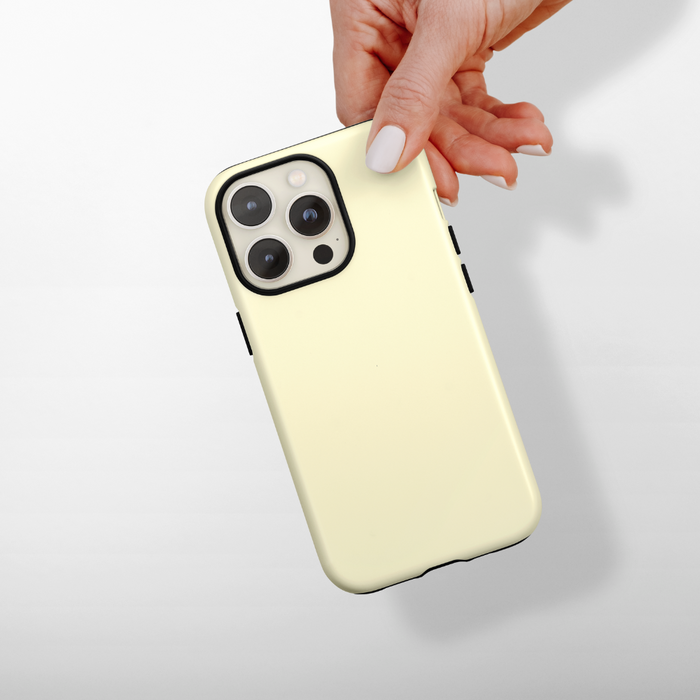 Hand holding a smartphone in a yellow Coconut Lane Tough MagSafe® phone case, set against a light gray background.