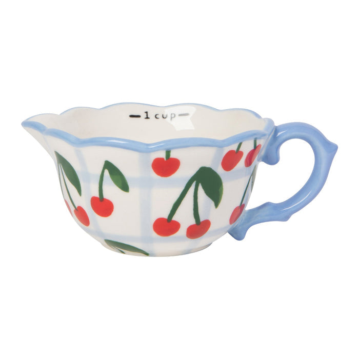 Ceramic measuring cup with cherry design on a white background