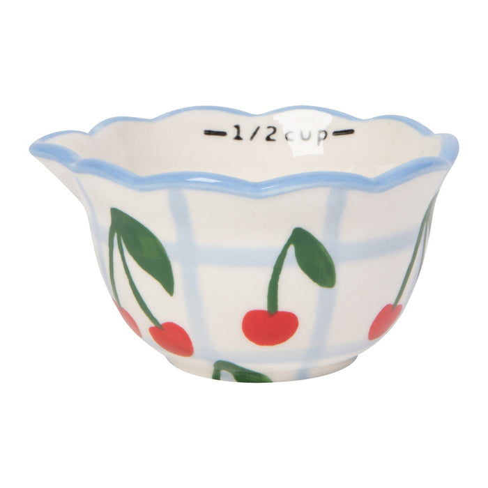 Ceramic measuring cup with cherry design on a white background