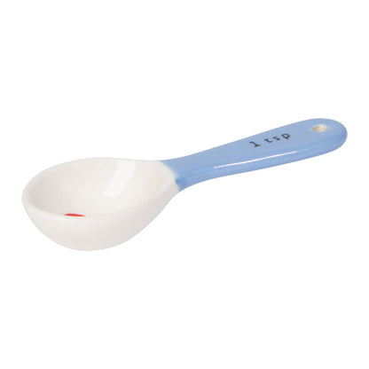 White measuring spoon with blue handle on a white background