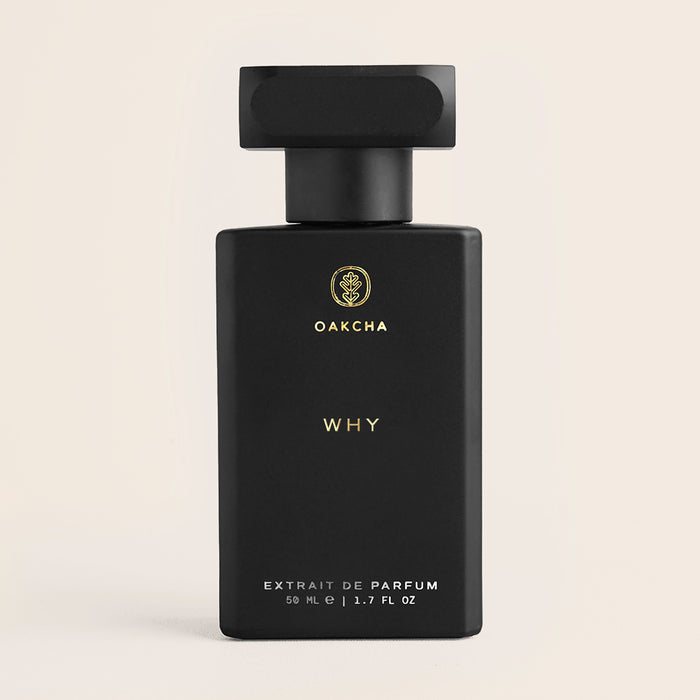 Front view of Why 50ml extrait de parfum bottle showing matte black rectangular bottle with gold Oakcha logo and WHY text on a light beige background