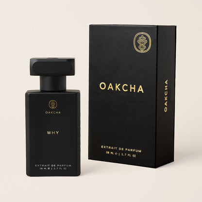Front-facing view of Why extrait de parfum bottle and matching box showcasing matte black finish and gold lettering on a light beige background
